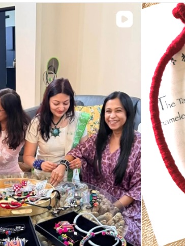 Friends trying on pinksanduk jewelry around a table of pieces